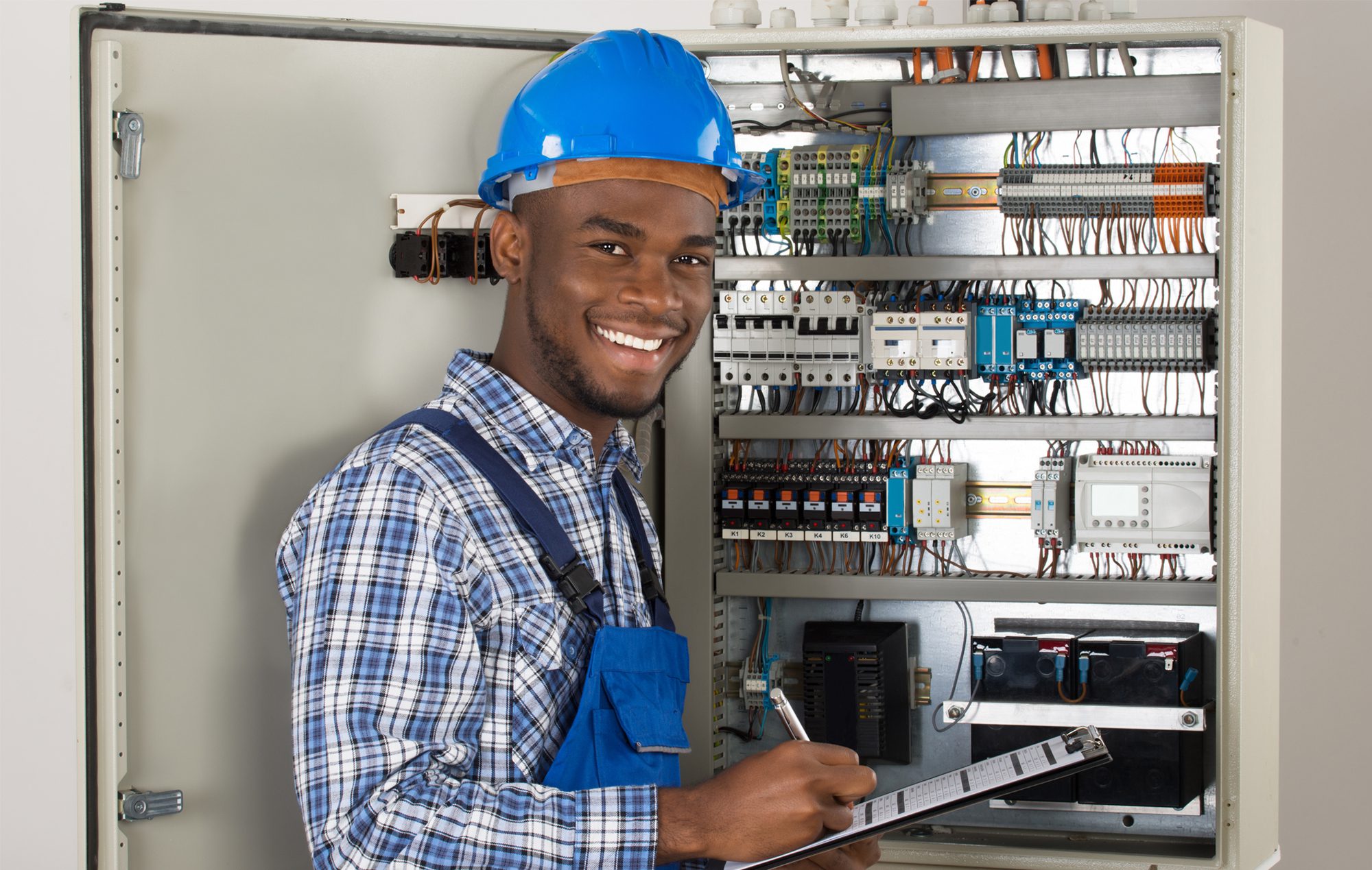 Happy Man in Blue Overalls Holding Clipboard.