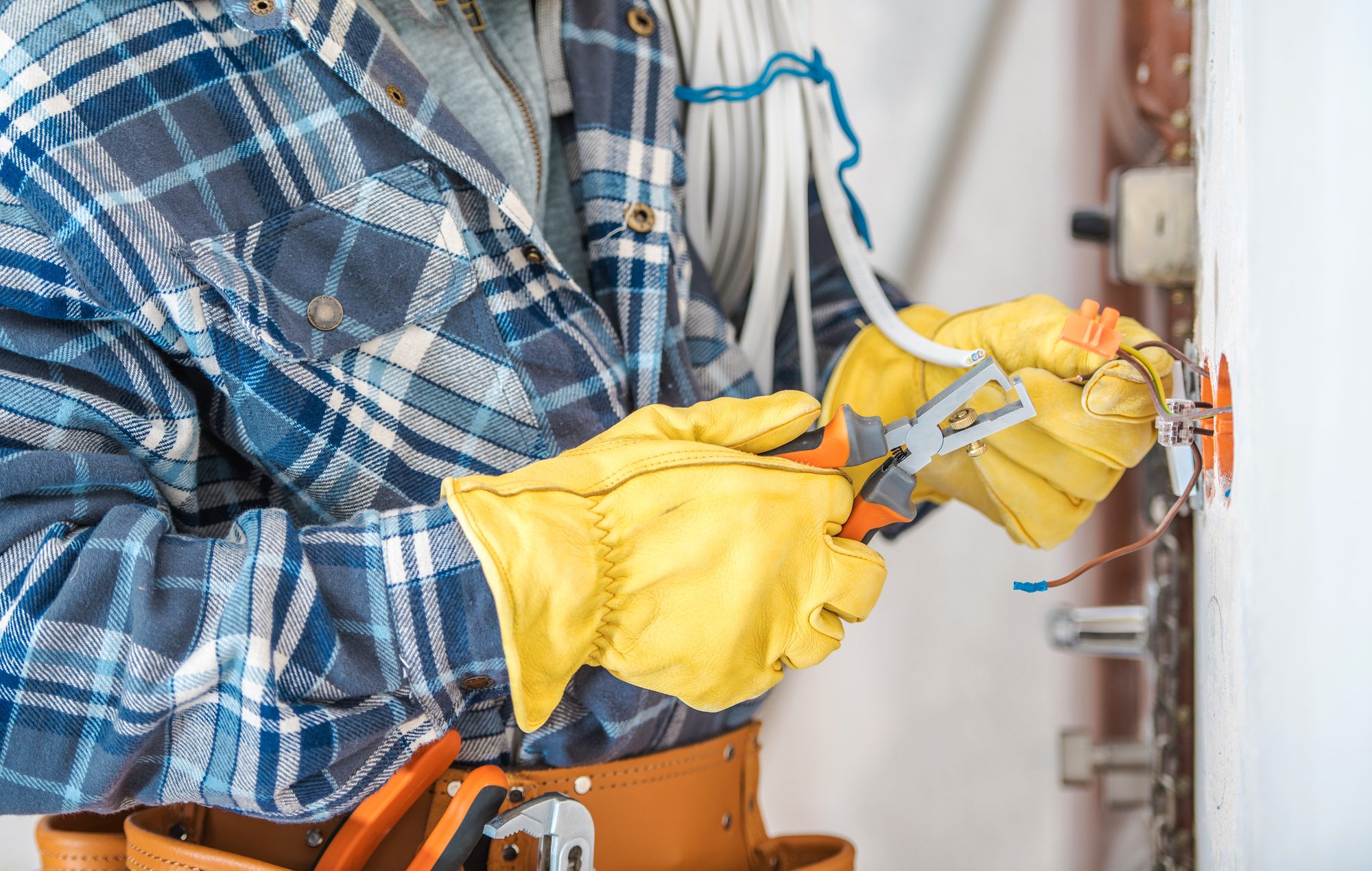 Plaid-Shirted Man With Yellow Gloves Holding Pliers.