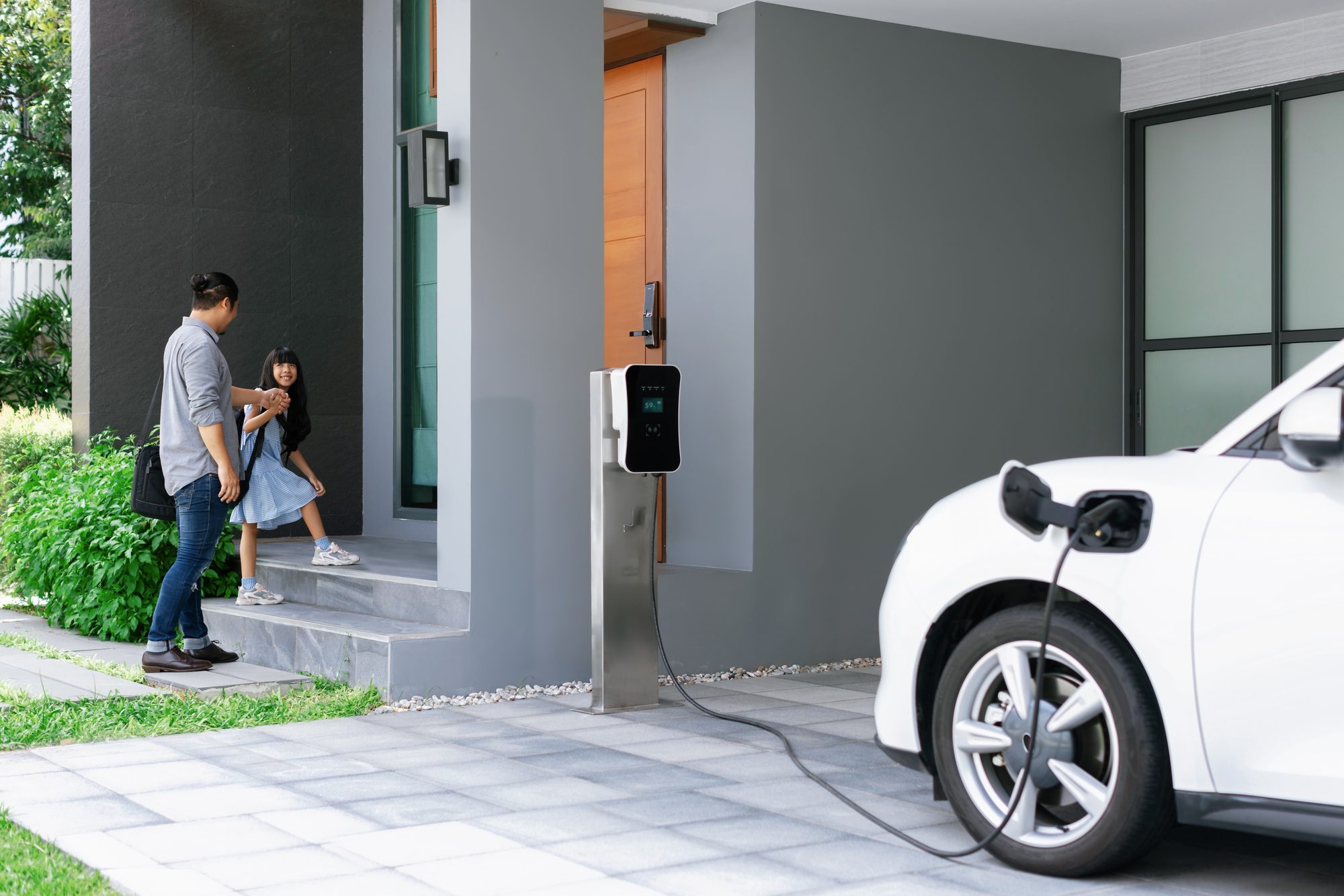 Man and Woman by Electric Car Charging at EV Station.